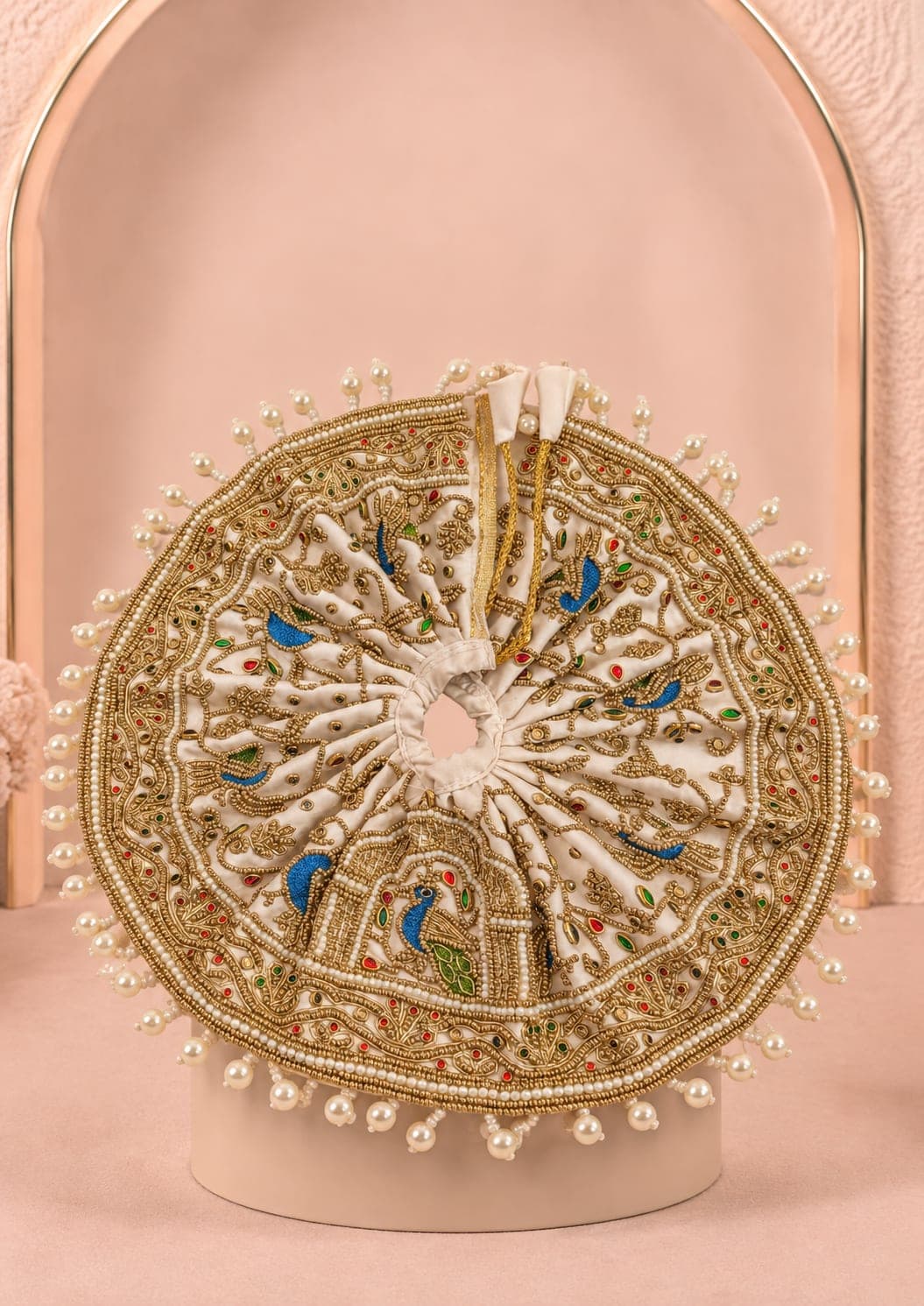 Designer mukut from the Kunja Shobha Set featuring ivory fabric, antique-gold embroidery, pearl detailing, peacock feathers and handcrafted embellishments for Laddu Gopal Ji