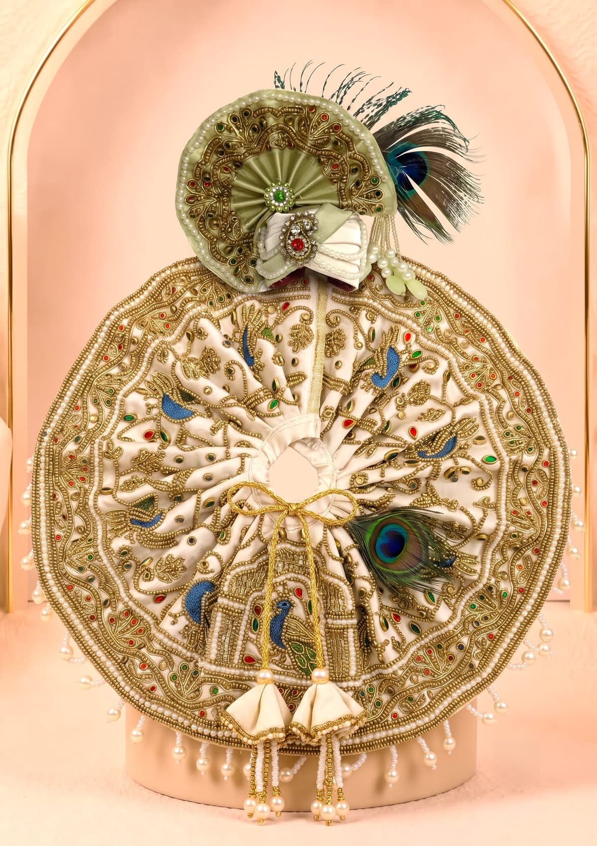 Kunja Shobha Set circular Laddu Gopal designer dress with matching handcrafted mukut, elegant ivory fabric, antique-gold embroidery, pearl detailing and peacock embellishments